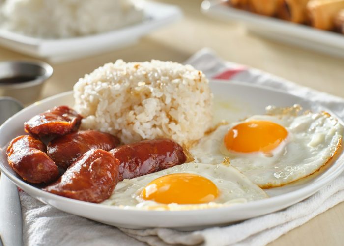 filipino silog breakfast with garlic fried rice, longsilog, and two sunny side up eggs