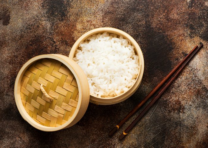 Rice jasmine in bamboo steamer with chopsticks